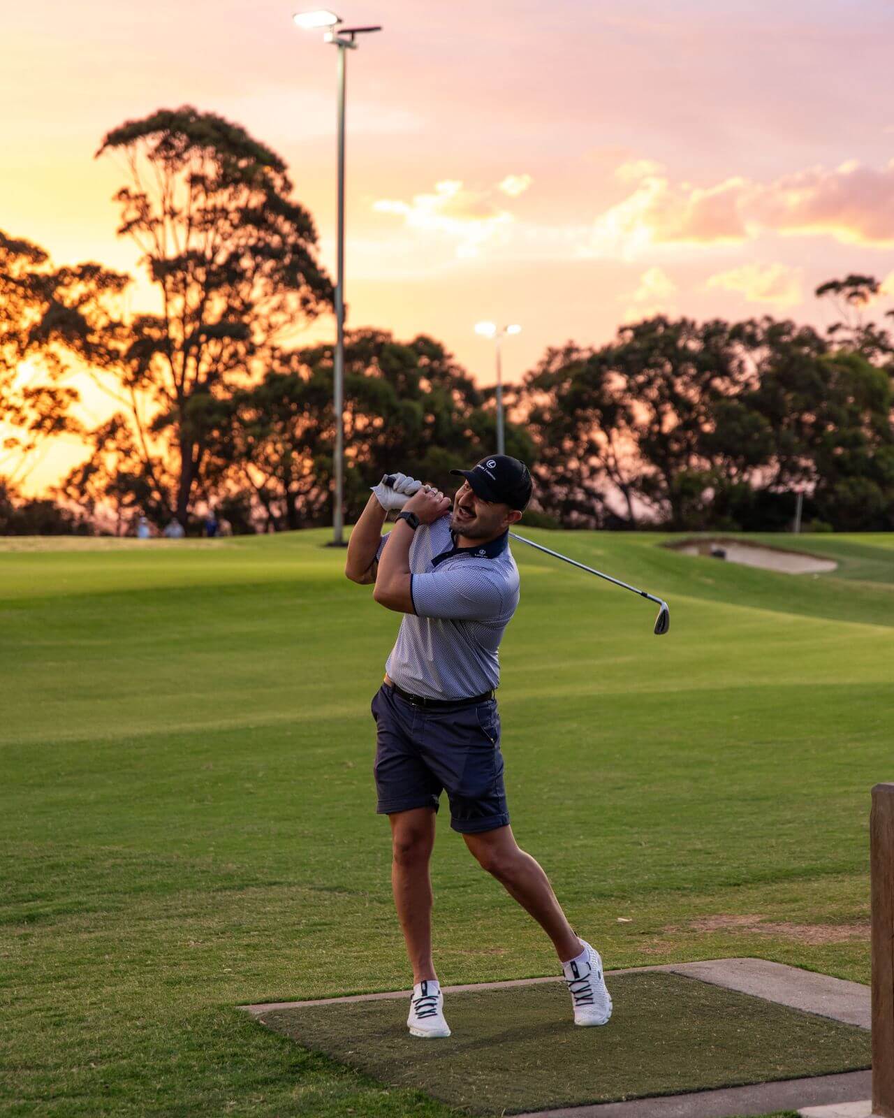Brand ambassador Nathan holding his follow-through pose after a golf swing at the Lexus of Chatswood Twilight Par3 event