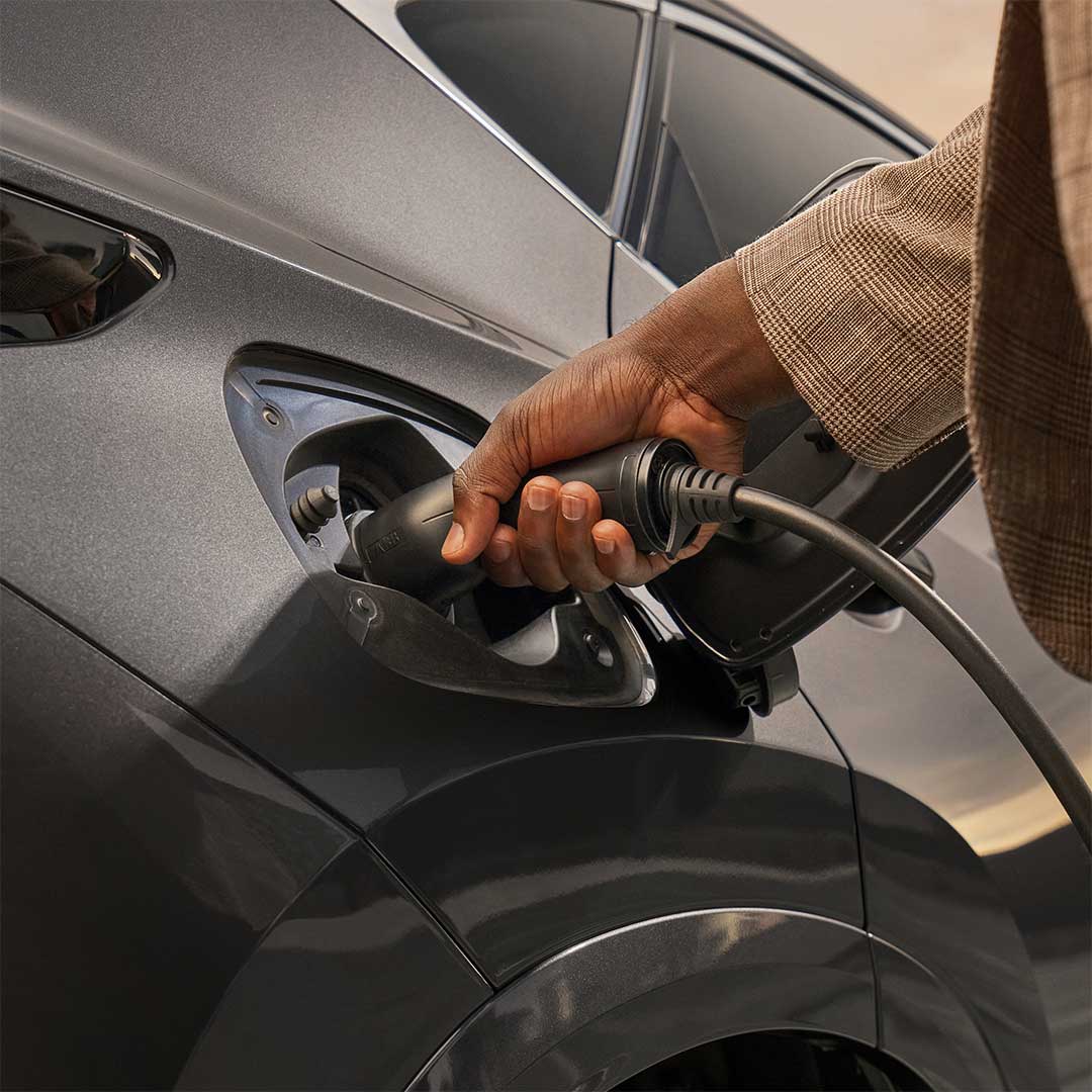 Hybrid Lexus vehicle, the NX 450h+, is shown being charged.