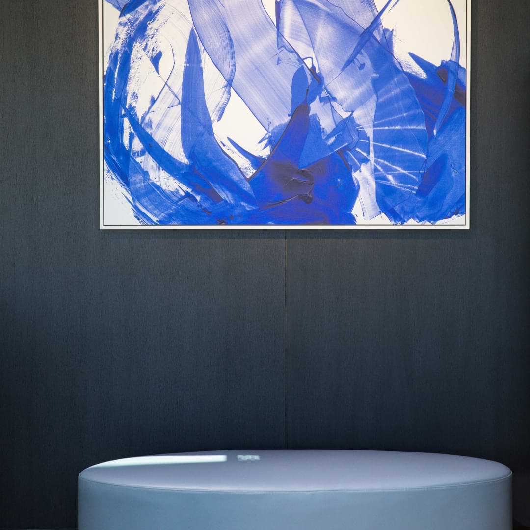 Furniture inside the Lexus tent - a blue couch sitting below artwork styled by Miriam Fanning and Grazia & Co