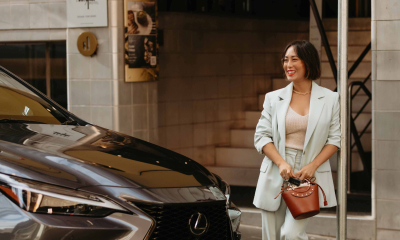 Lexus Ambassadors Lexus Brand Ambassador Melissa Leong stands beside dark grey Lexus LX SUV on a city street.