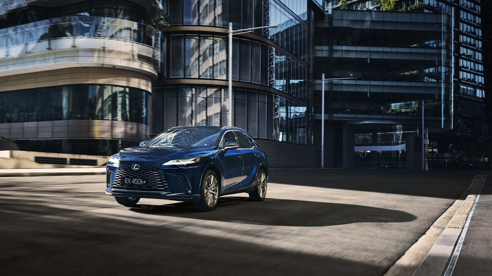 Blue Lexus RX 450h+ Plug-in hybrid driving through a modern urban environment with glass office buildings.