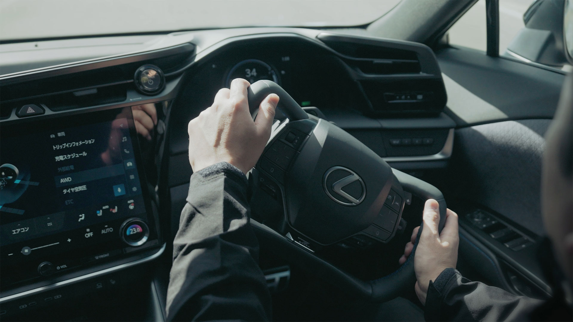 Two hands steering the steering wheel of the Lexus RZ vehicle