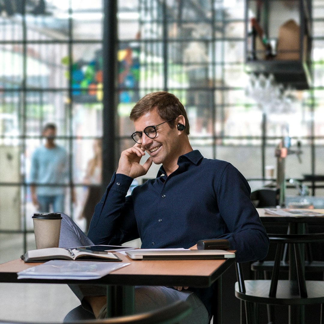 Business man talking into bluetooth headset, smiling at a Lexus dealership